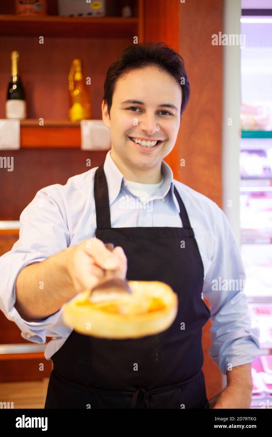 Shopkeeper serving pizza to a customer in grocery store Stock Photo Alamy