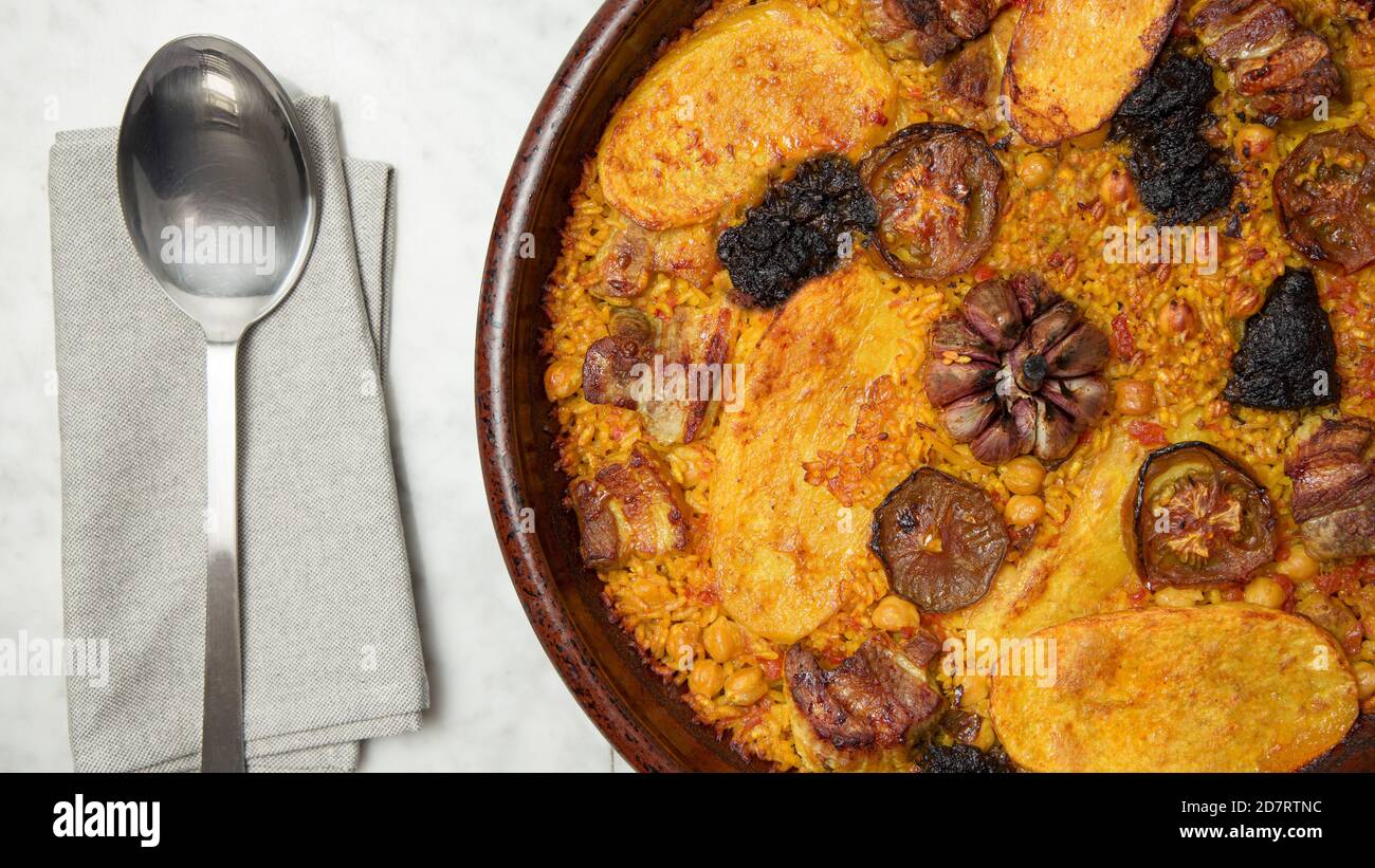 Delicious oven baked rice on a marble table, ready to serve. Valencia, Spain Stock Photo
