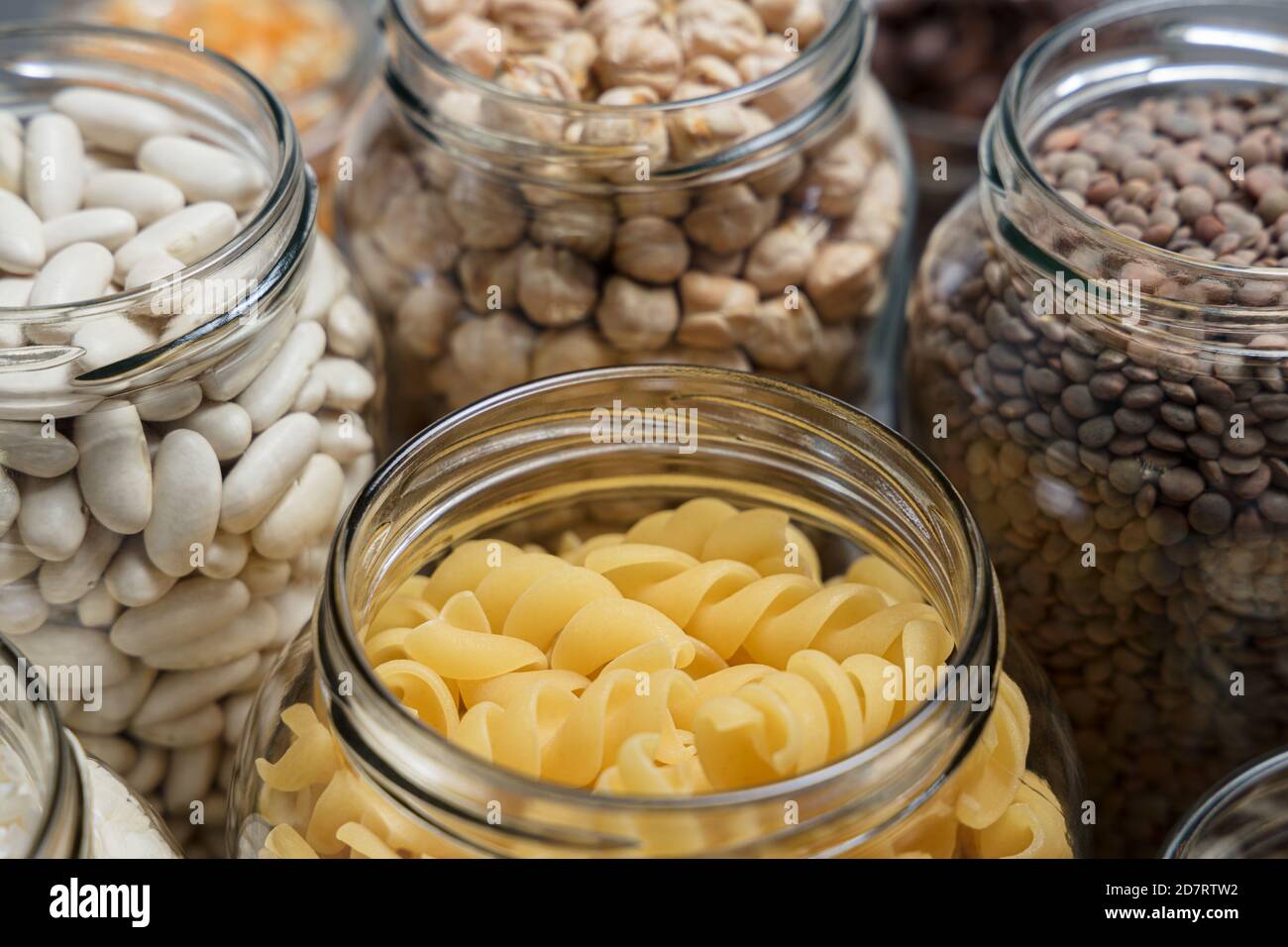 Set of glass jars with various ingredients placed on a table. Zero waste concept. Stock Photo