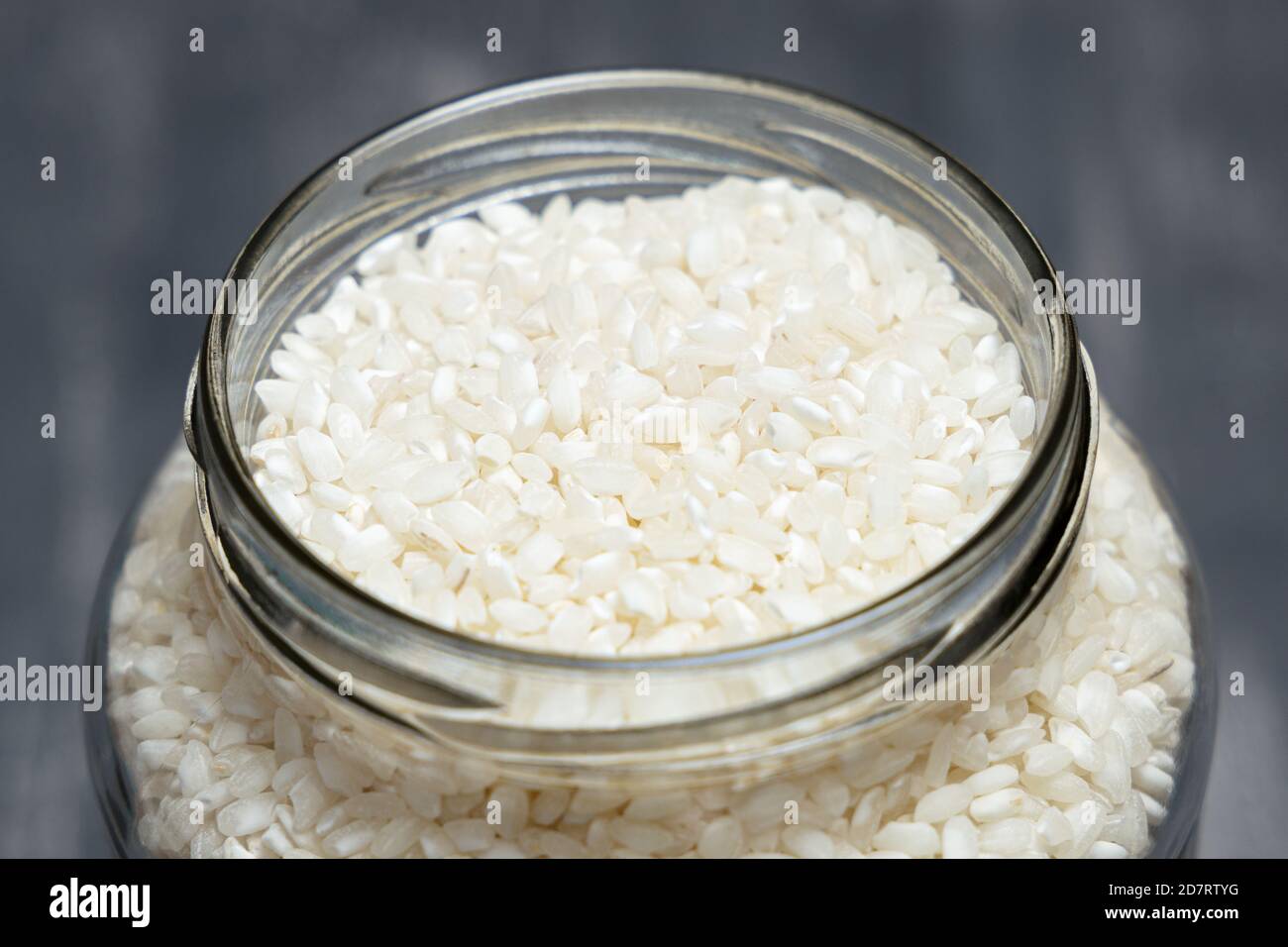 Close up of a big glass jar full of rice placed on a tabletop. Eco