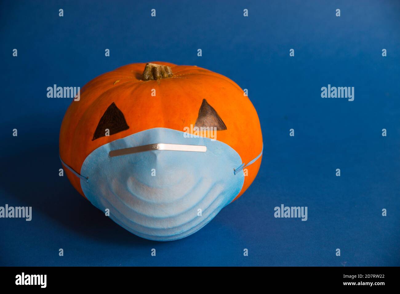 Covid pandemics: Halloween pumpkin wearing mask. Stock Photo