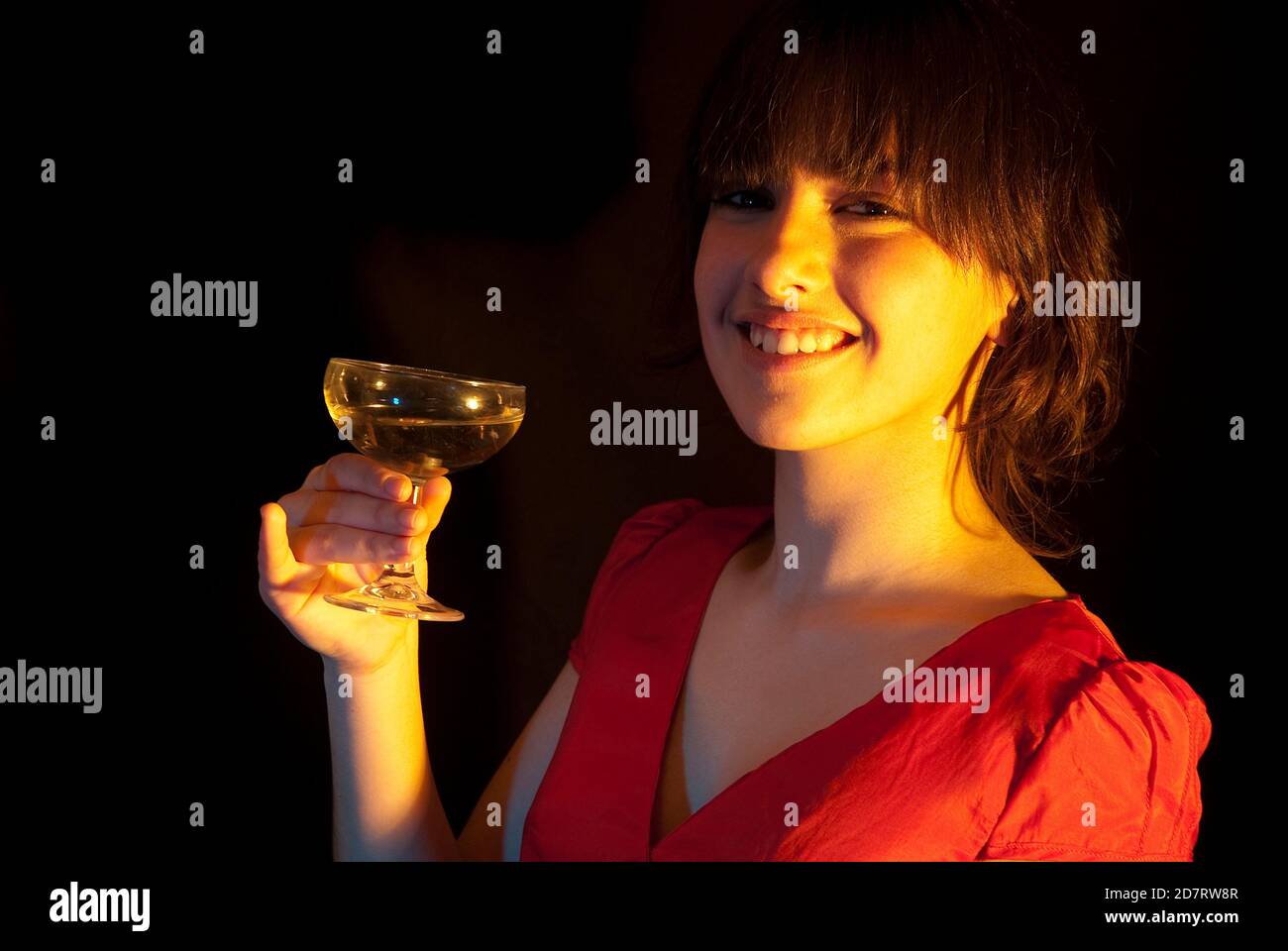 Young woman toasting, smiling and looking at the camera. Stock Photo