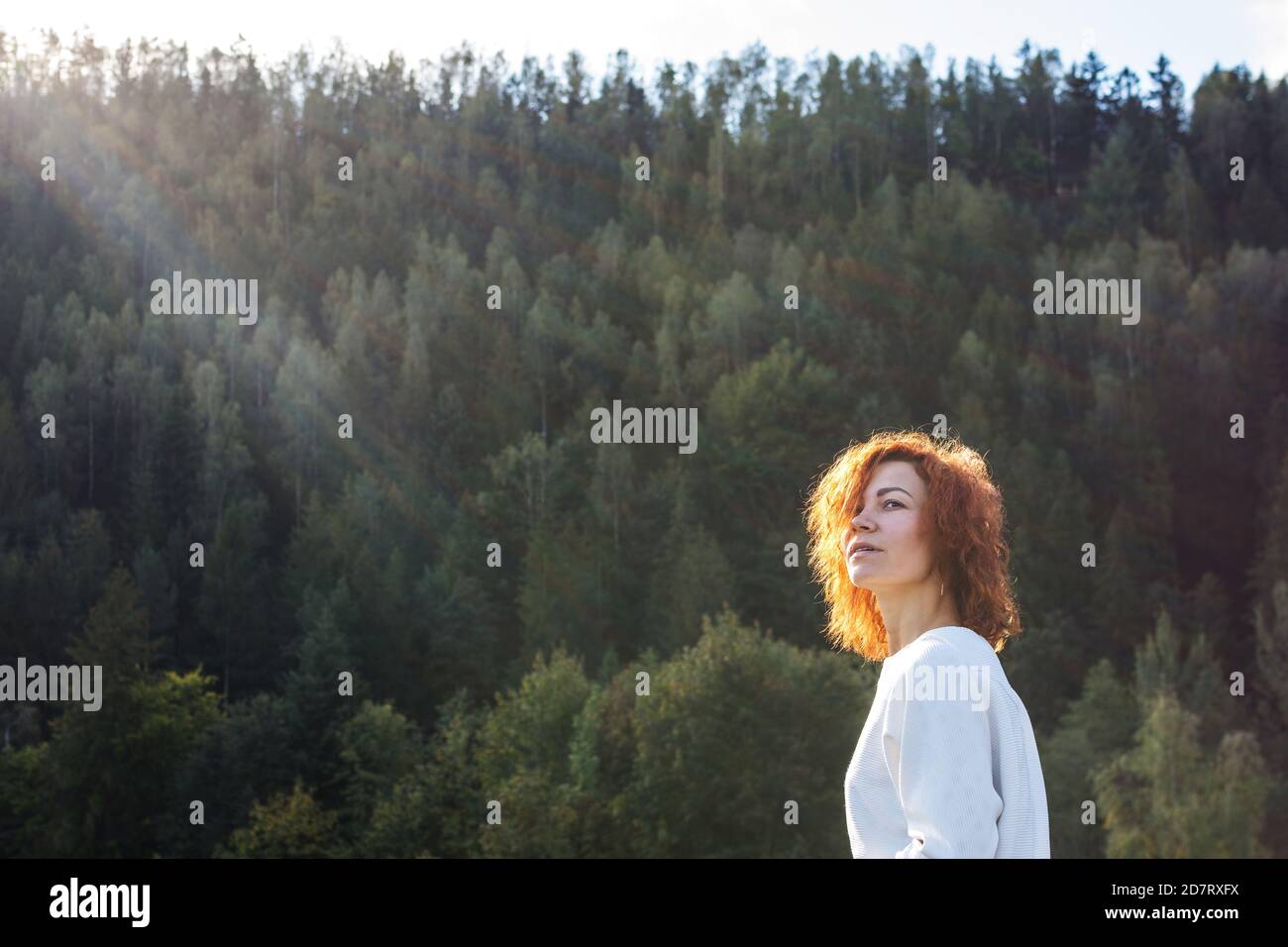 cute redhead girl enjoying the sun in the forest Stock Photo - Alamy