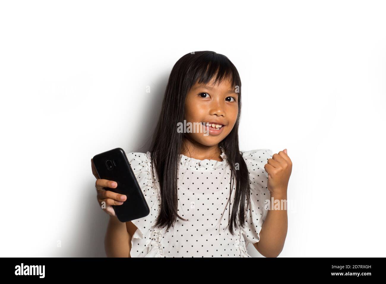 Happy asian little girl using smart phone on white background Stock ...