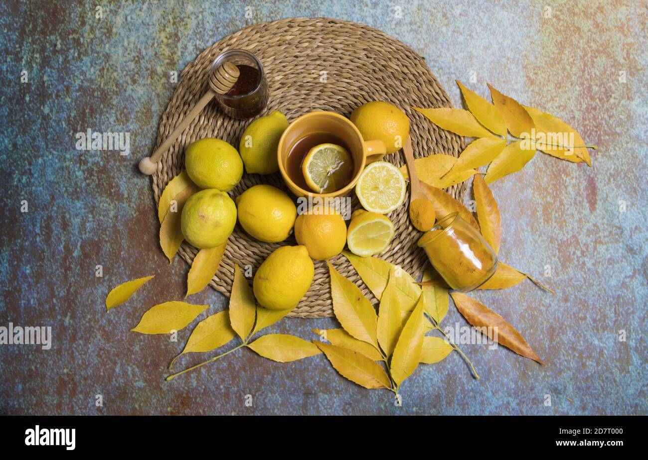 Still life of lemons, honey, turmeric and herbal tea, on a blue background Stock Photo