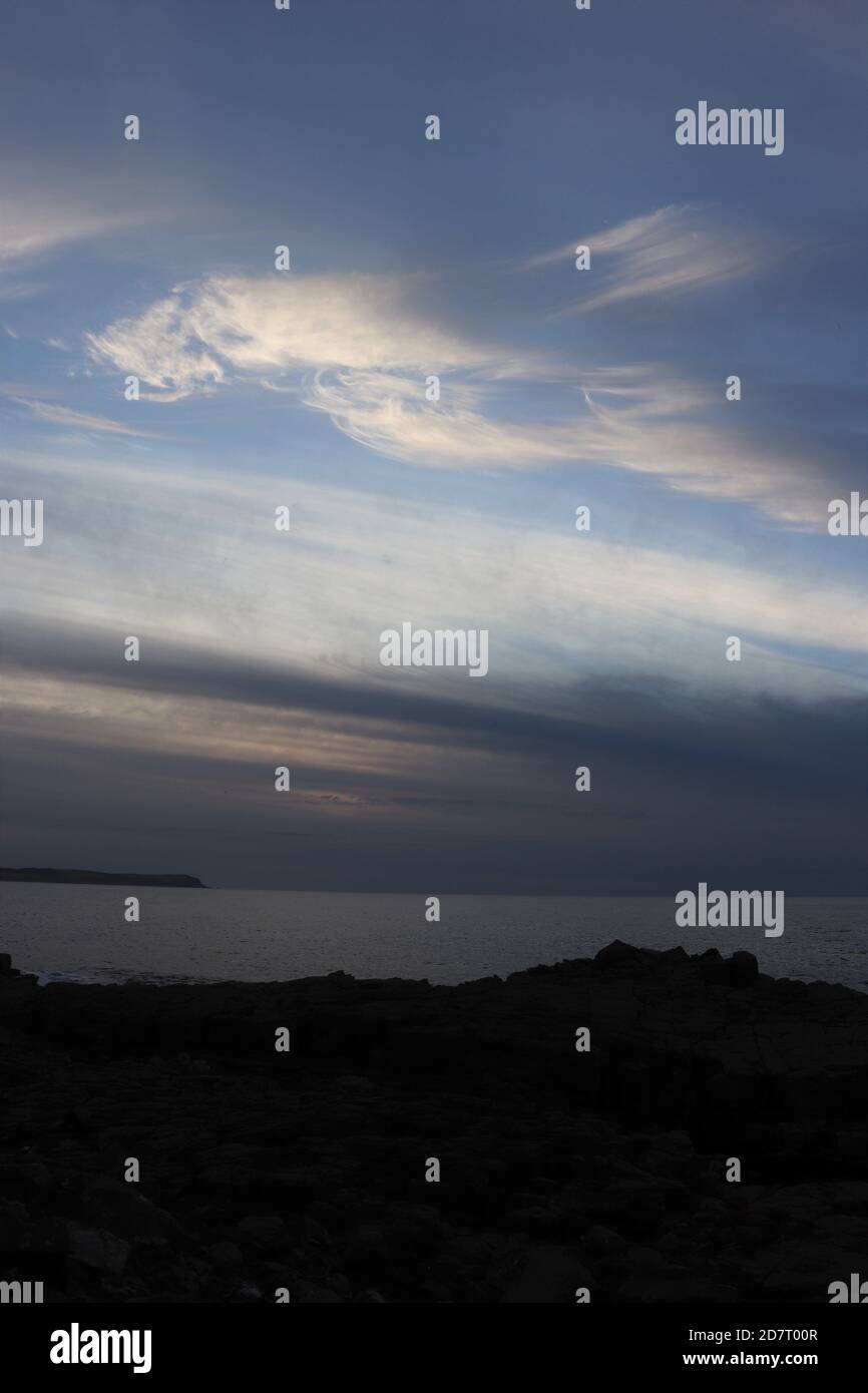 Twilight sky over sea and silhouettes of land Stock Photo - Alamy