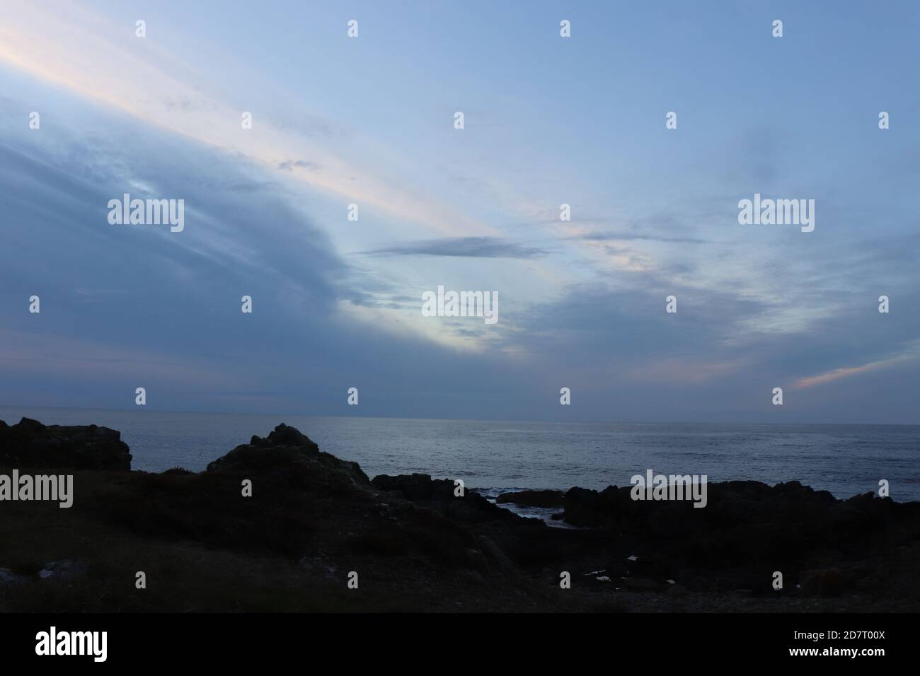 Twilight sky over sea and silhouettes of land Stock Photo - Alamy
