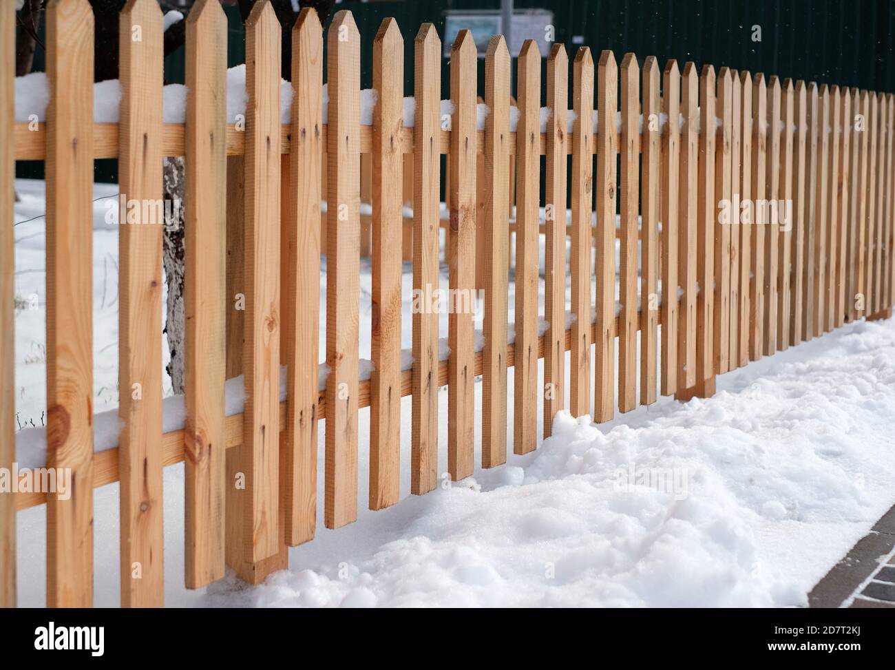 Wooden fence covered with snow around garden in winter time Stock Photo ...