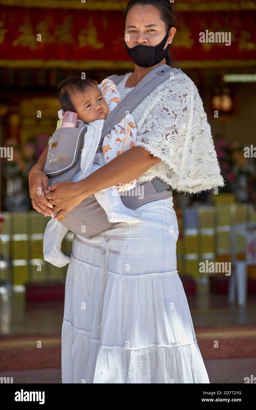 Mother carrying baby in a sling harness. Thailand Southeast Asia Stock Photo