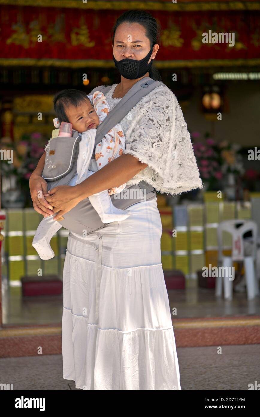 Mother carrying baby in a sling harness. Thailand Southeast Asia Stock Photo