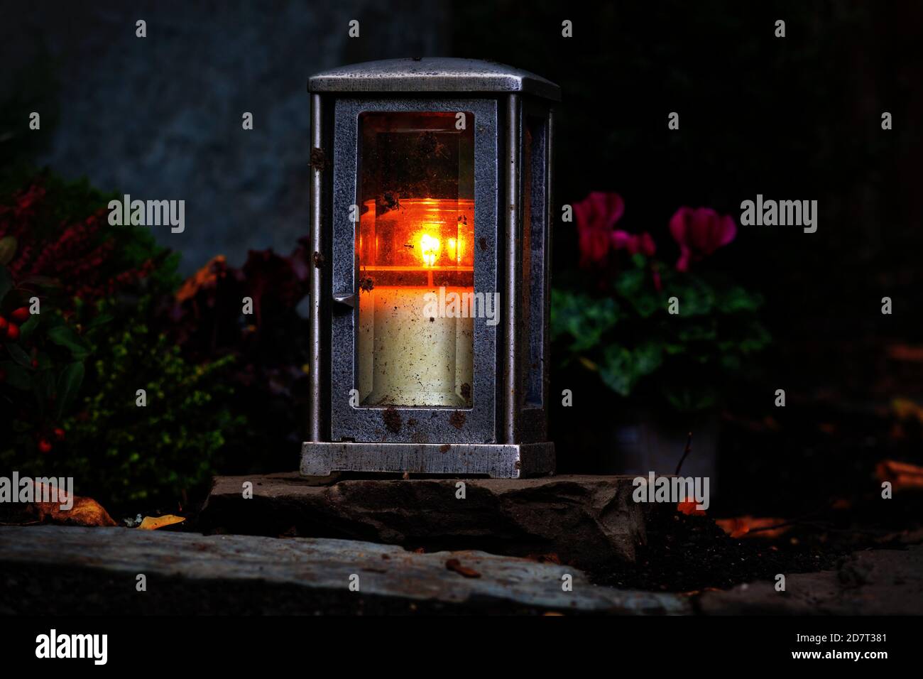 Grave lantern with burning candle at night in a cemetery Stock Photo