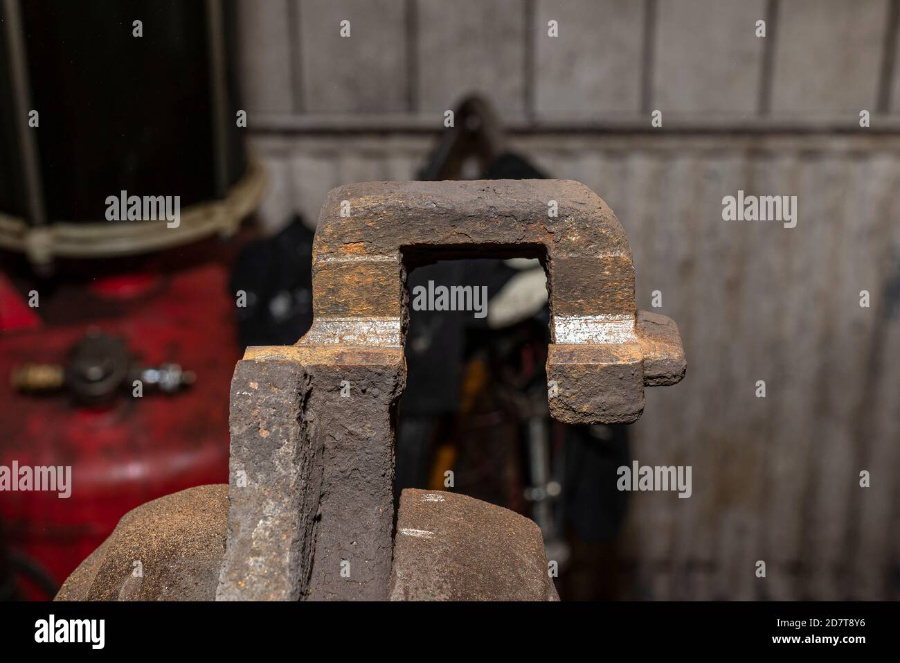 Rusty brake caliper after removing the rust, attached to a bench vise