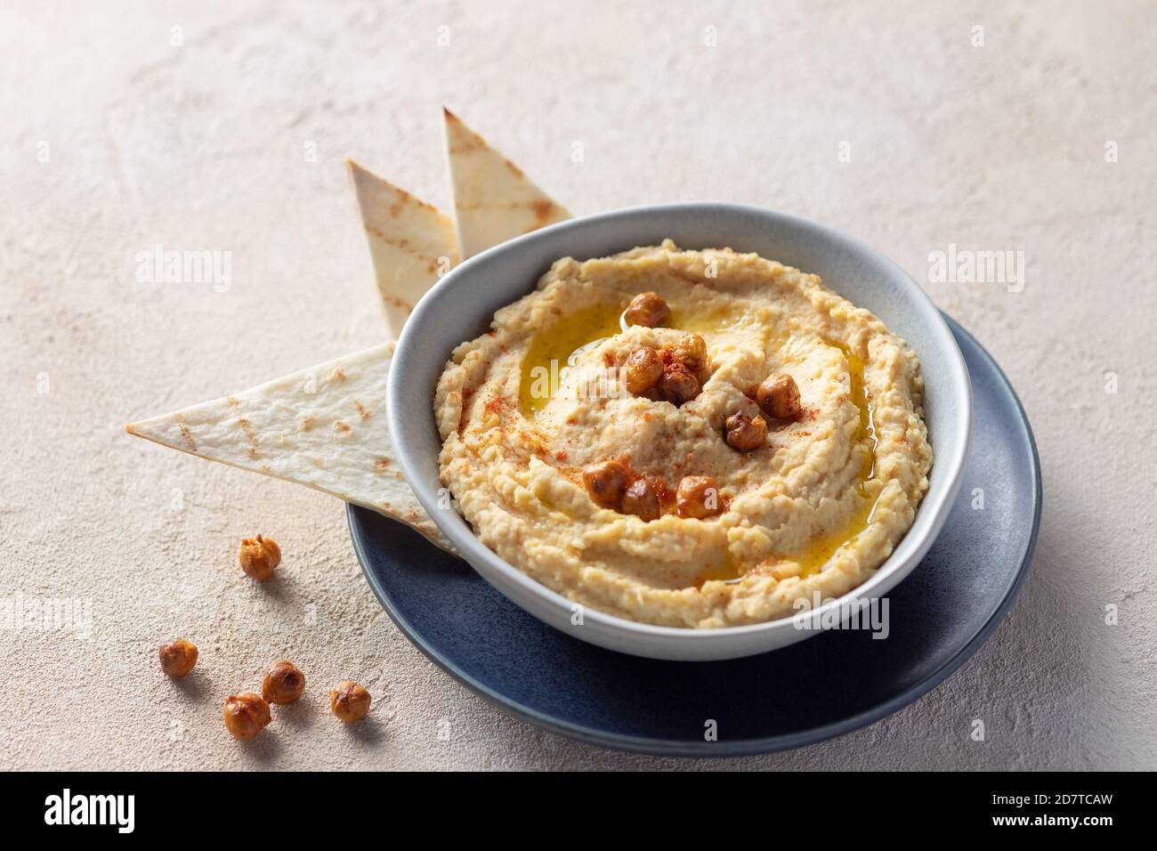 close-up of bowl of homemade hummus with roasted chickpeas, olive oil and spices. Stock Photo