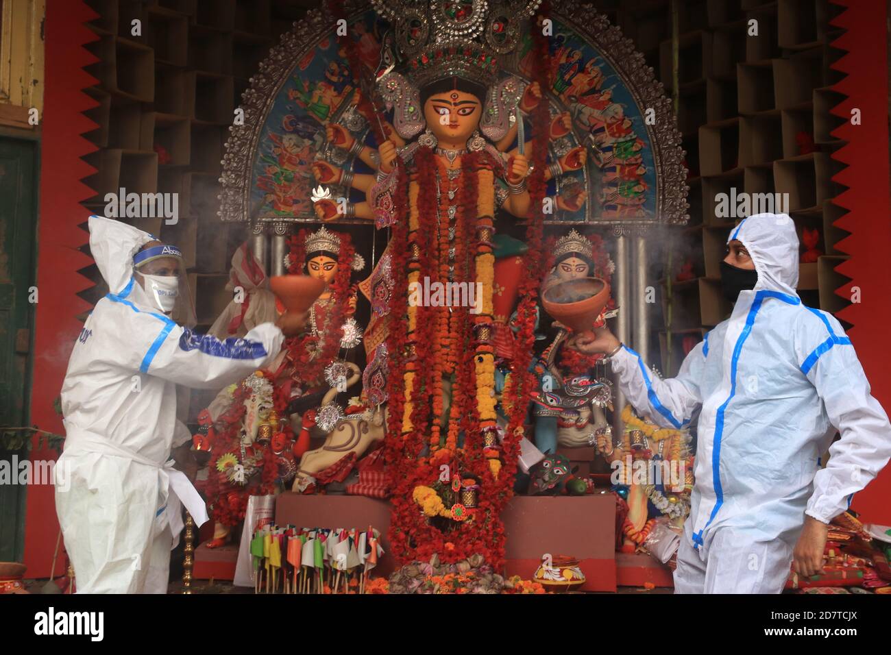 Kolkata, India. 25th Oct, 2020. Hindu devotees wearing PPE perform the traditional dance of Dhunuchi in front of Hindu goddess Durga idol during Durga Puja Festival in Kolkata. About 90 per cent of Covid patients have recovered in India so far, the Health Ministry said this morning, adding that the country has logged over 78.64 lakh cases since the beginning of the pandemic. In the last 24 hours, the country reported 50,129 new infections; 578 deaths in a day have pushed the total Covid-linked fatalities to 1, 18,534. India is the second worst-hit country in the world by the pandemic after the Stock Photo