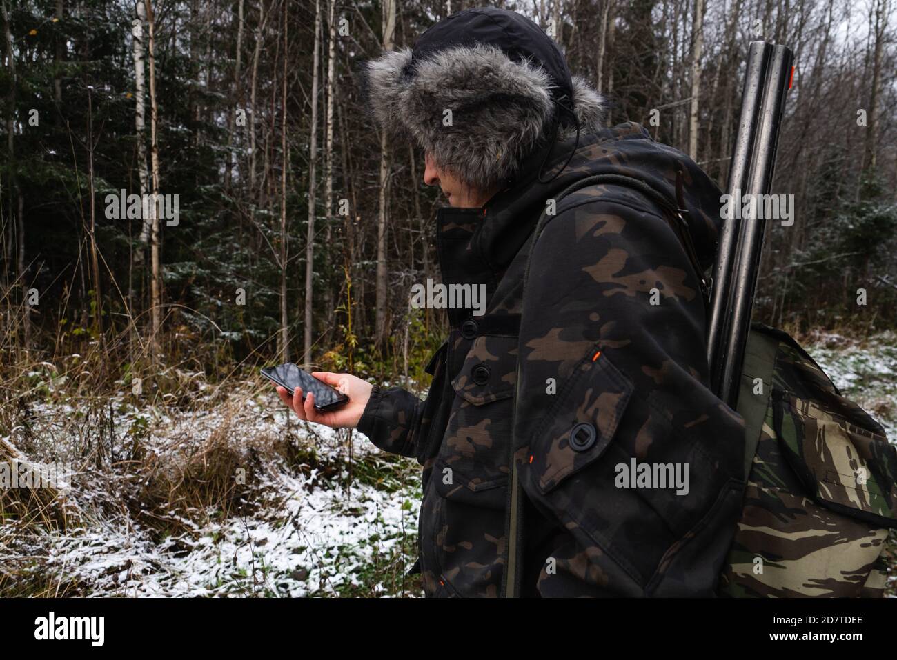 Hunter with smartphone in a winter forest Stock Photo