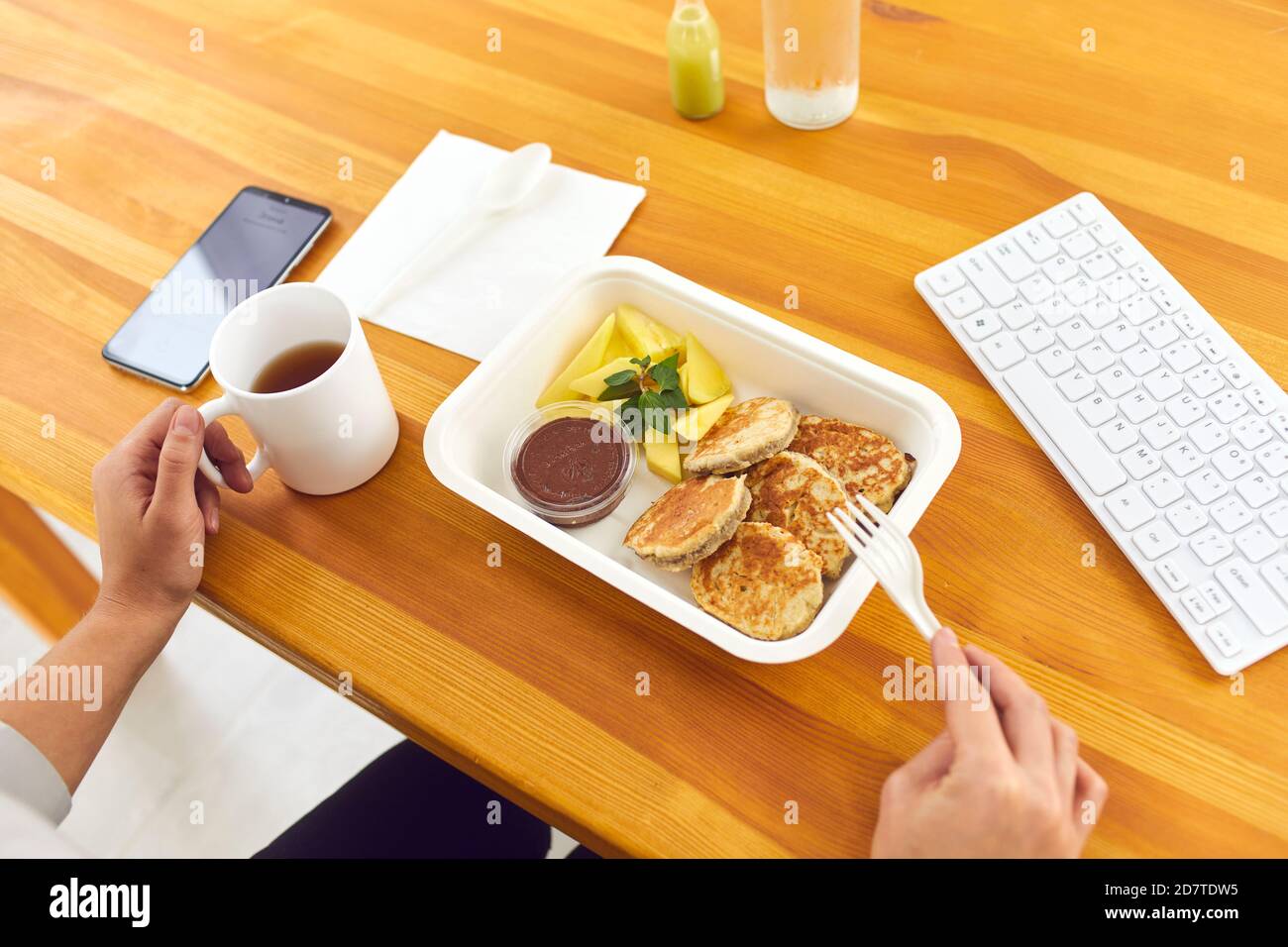 Hands of office worker eating healthy balanced meal from container in office Stock Photo