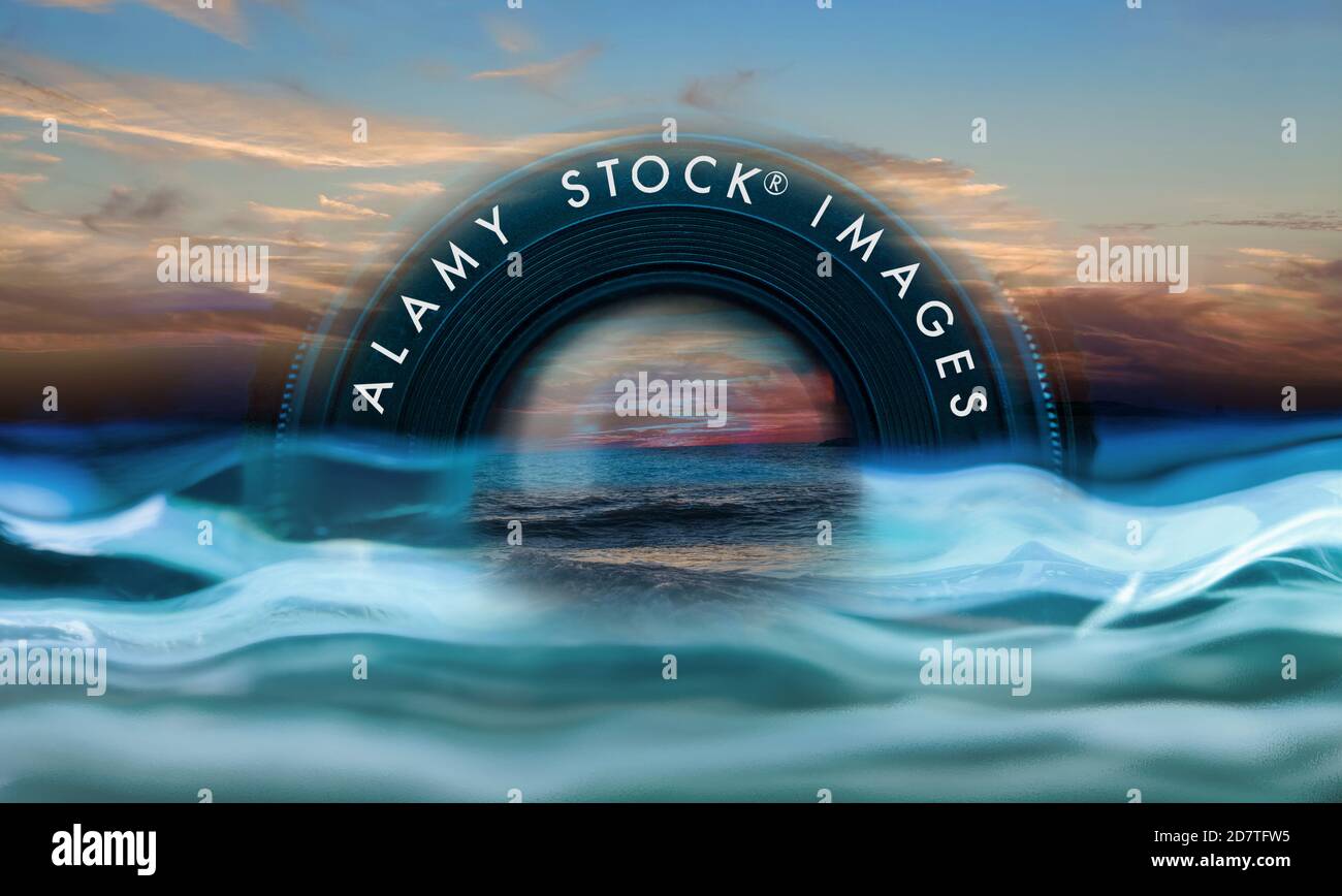 On the upper half of the lens it is written ALAMY STOCK IMAGES. Surrealist atmosphere, a camera lens that looks like a rainbow above the 'water'.. Stock Photo