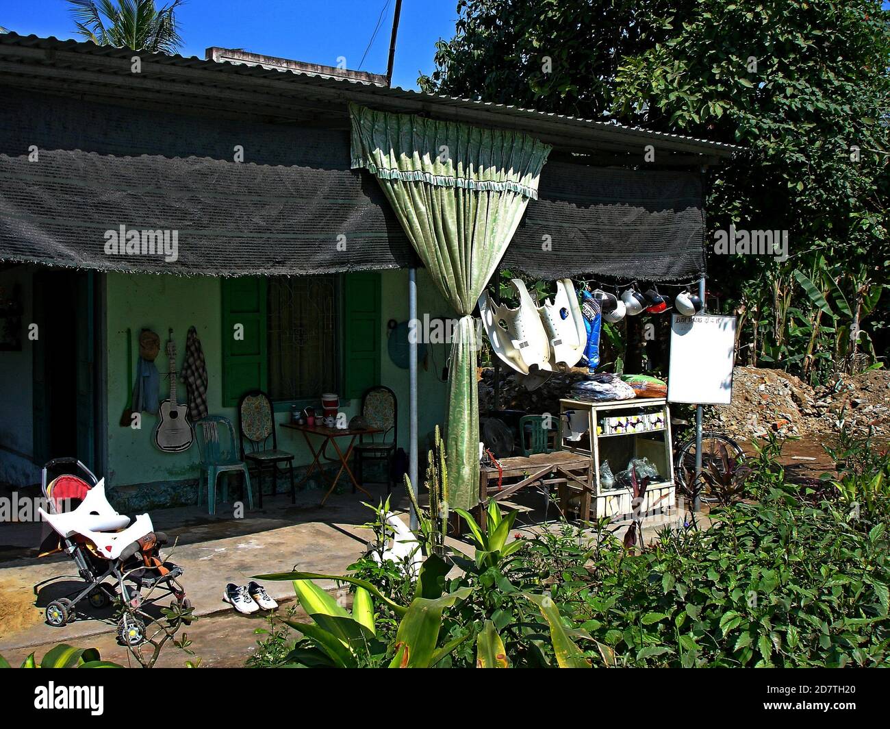 Small family cafe gives the traveller shade on the Vietnamese roadside. Stock Photo