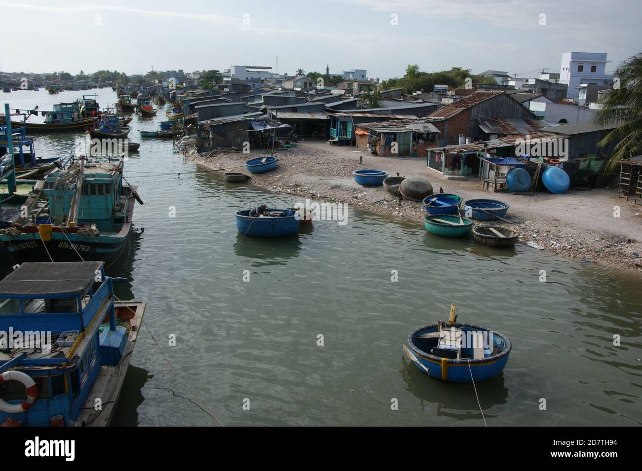 Coracles and fishing boats by the ramshackle Phan Thiet fishing village. Stock Photo
