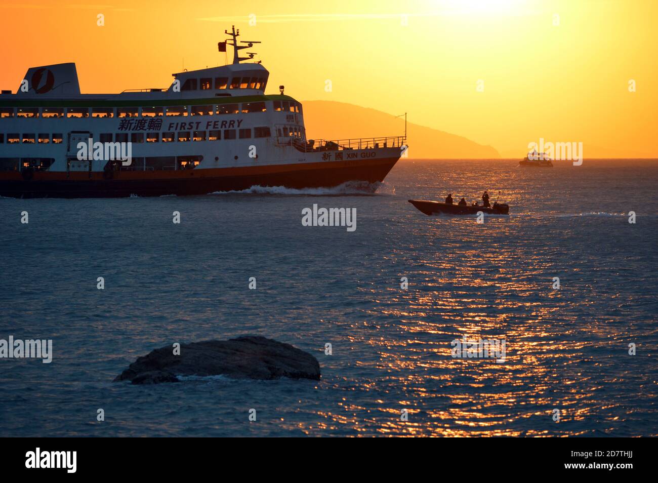 Triple-decker Hong Kong passenger vessel 'Xin Guo' of First Ferry, which serves the outlying island of Cheung Chau. Pictured departing Cheung Chau. Stock Photo
