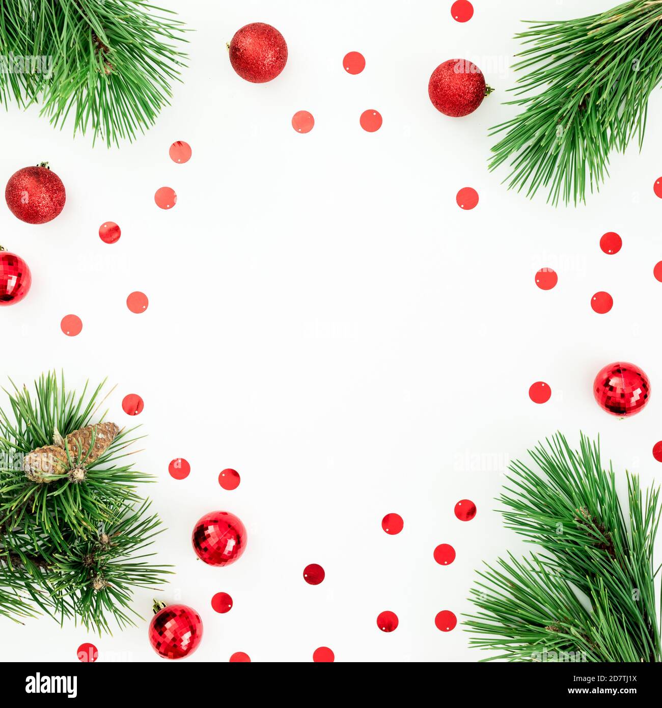 Christmas frame made of pine branches and red balls with confetti on ...