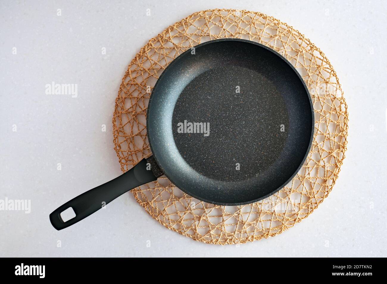 Frying pan on woven napkin, flat lay kitchenware Stock Photo