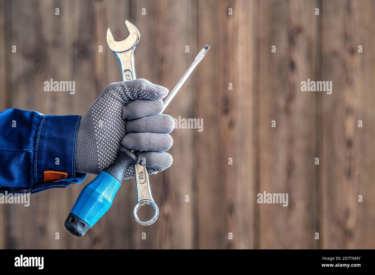 Locksmith maintenance work. The master holds a key and a screwdriver in his hand Stock Photo