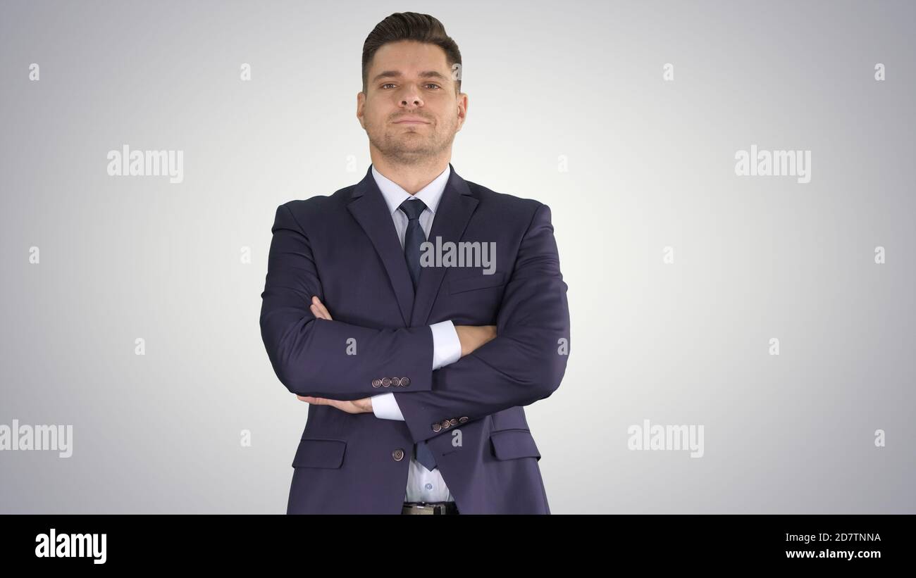 Businessman with fo;ded hands looking to camera on gradient back Stock Photo