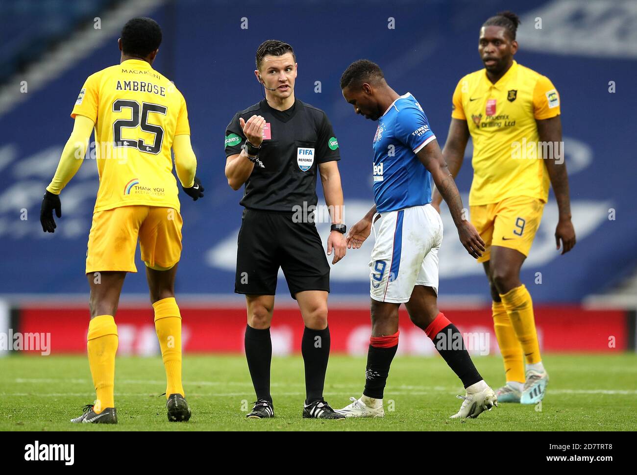 Referee Nick Walsh (centre) speaks with Livingston's Efe Ambrose (left) during the Scottish Premiership match at Ibrox Stadium, Glasgow. Stock Photo