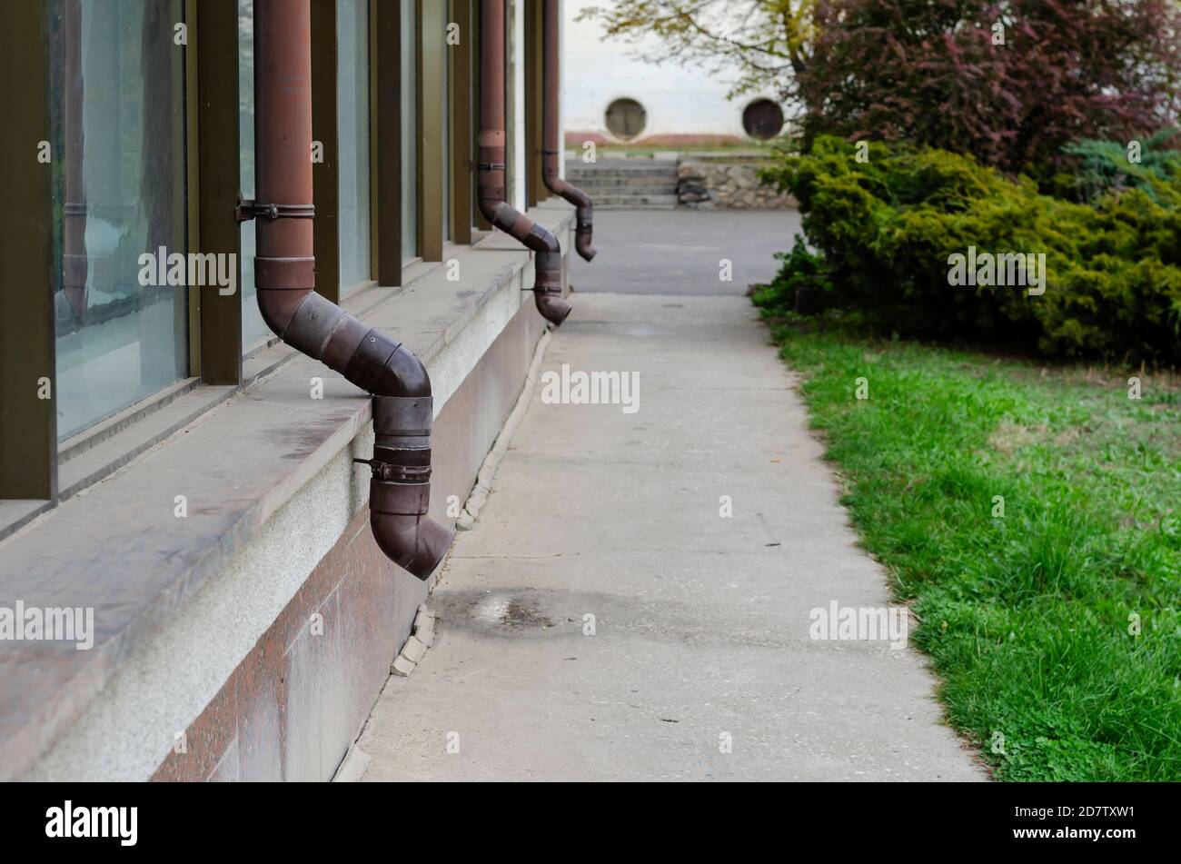 Facade of building with attached brown gutters. Row of plastic rain