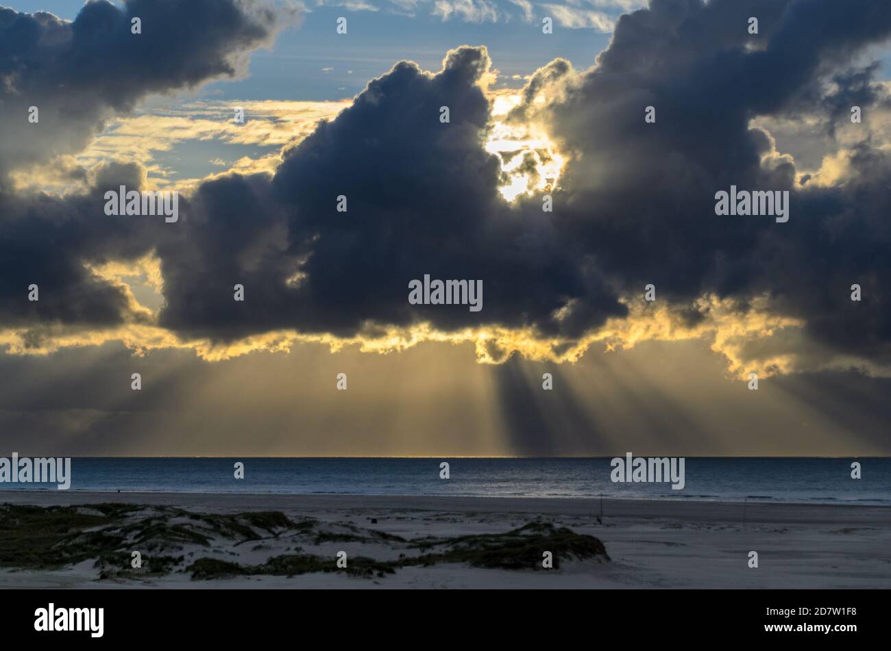 Amrum island, Germany: sun rays emerging through the dark storm clouds ...