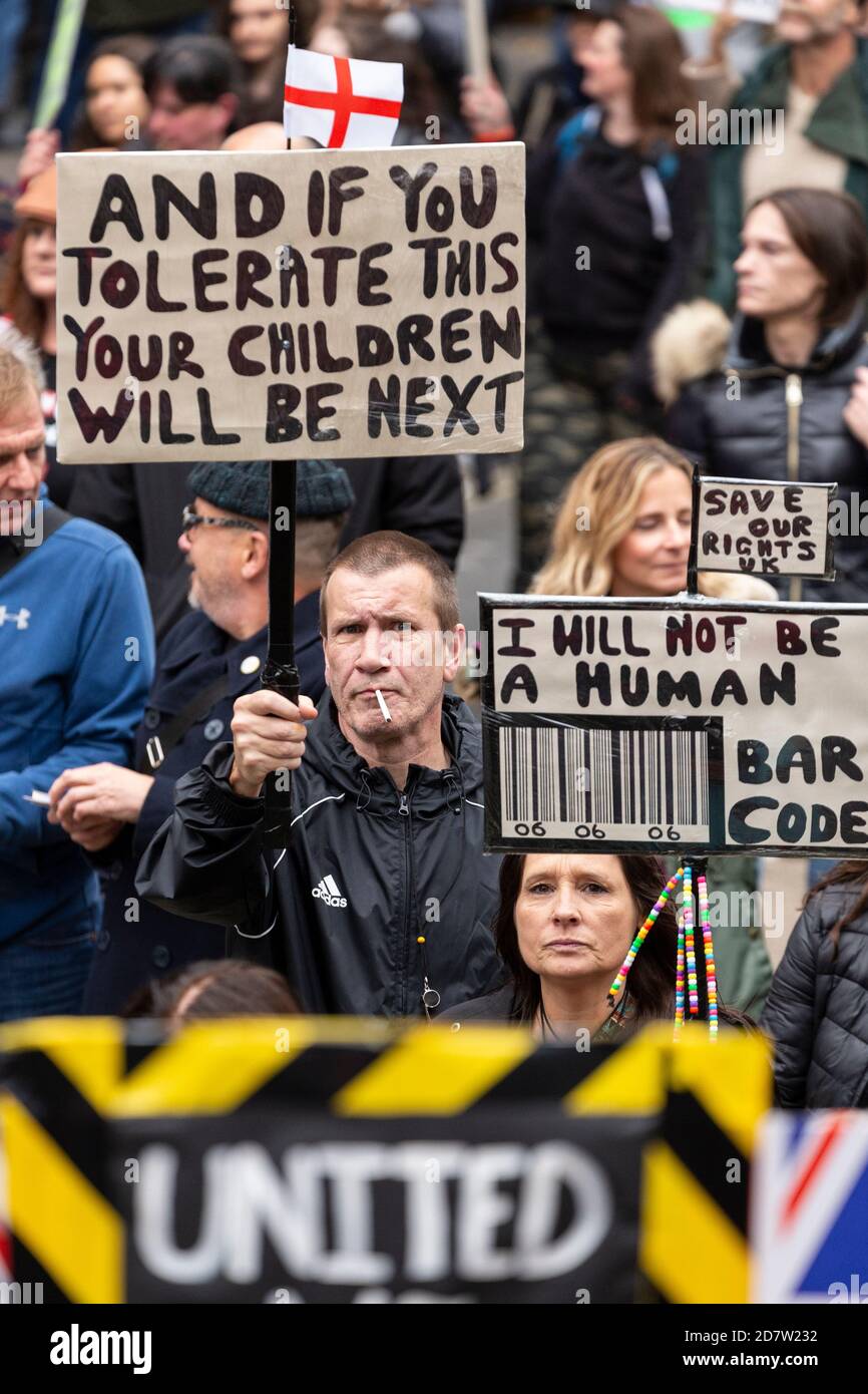 Protesters hold up signs amongst marching crowd during an anti-lockdown rally in London, 24 October 2020 Stock Photo