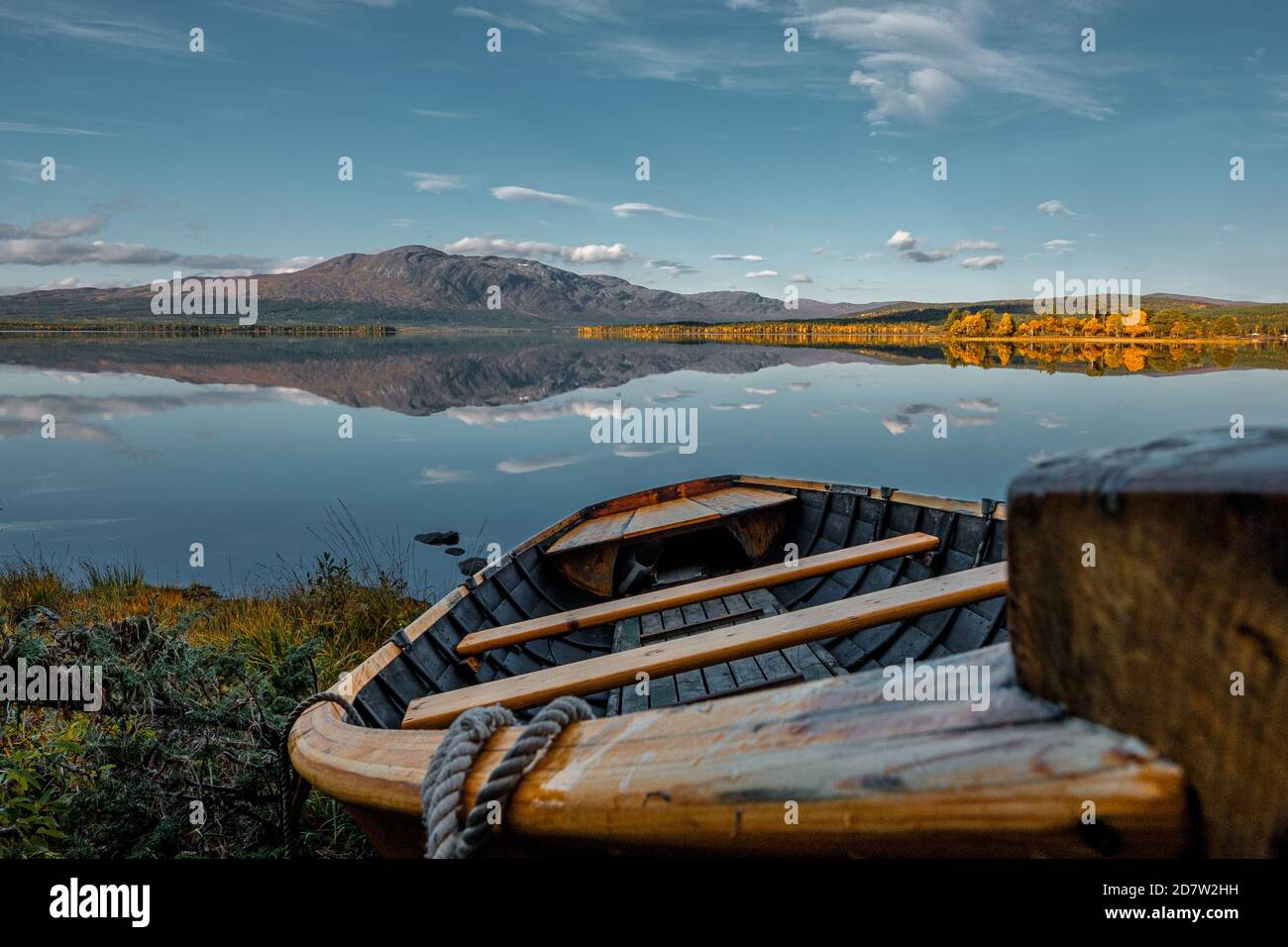 Old wooden boat on the shore of a lake during sunset Stock Photo - Alamy