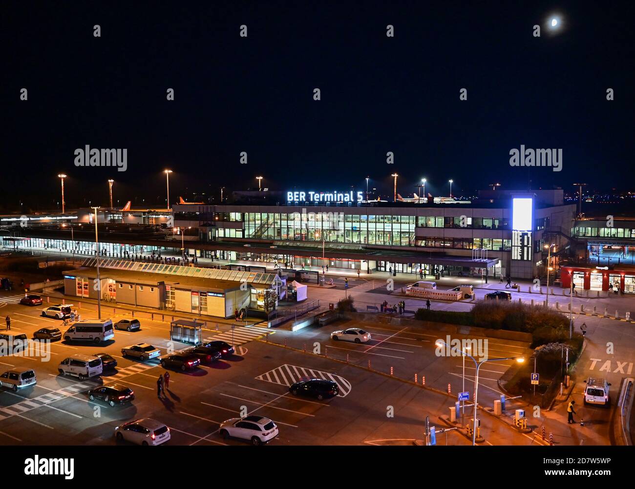 25 October 2020, Brandenburg, Schönefeld: The new lettering 'BER Terminal 5' lights up in the evening on the roof of the former Berlin Schönefeld airport. Berlin's airports are given the new abbreviation BER. A few days before the opening of the new Capital Airport, the previous codes TXL (Tegel) and SXF (Schoenefeld) will no longer be used when the winter timetable changes. The opening of the Capital Airport BER is planned for 31.10.2020. Photo: Patrick Pleul/dpa-Zentralbild/ZB Stock Photo