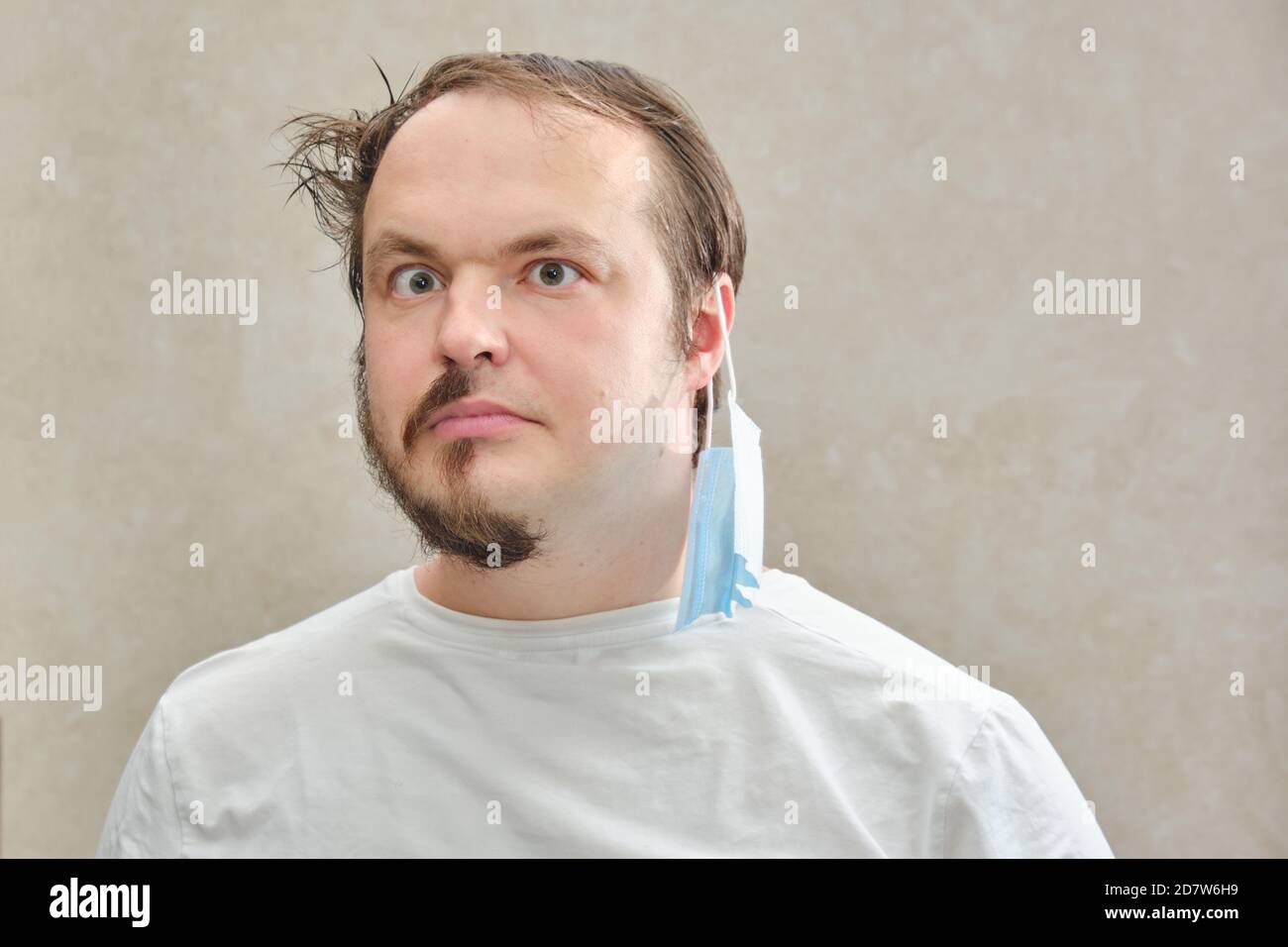 Adult man before and after the coronavirus epidemic, the concept of closed hairdressers and barbershops. Portrait of a man with a half-shaved beard an Stock Photo