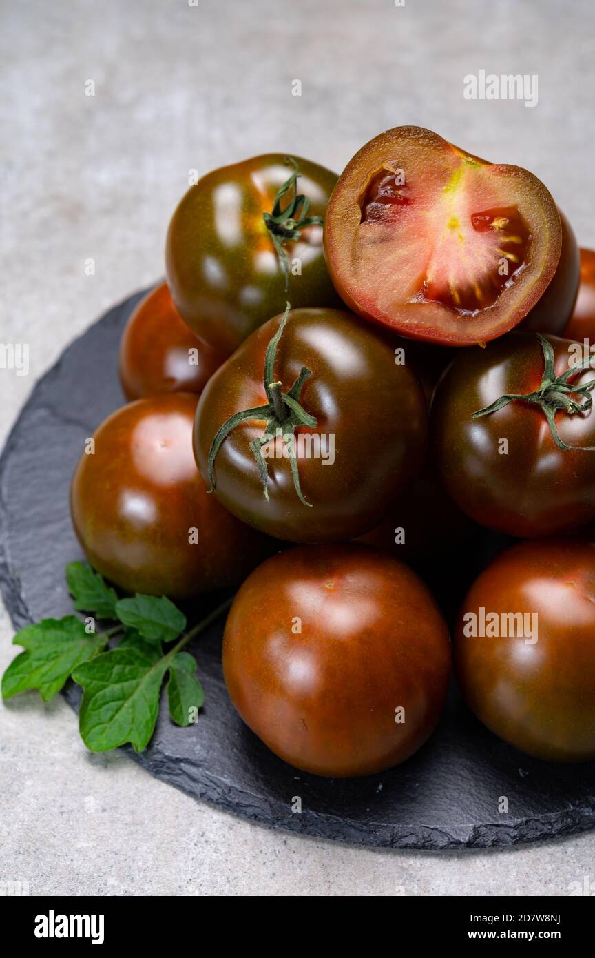 Fresh ripe sweet reddish brown and green kumato tomatoes close up Stock