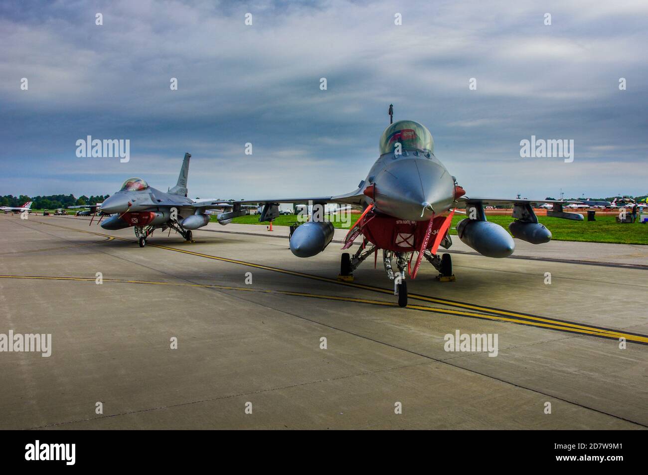 Shiloh, IL--Sept 12, 2012; two f-16 Fighting Falcon fighter jets of the Alabama Air National Guard sit parked on a tarmac with cloudy sky background Stock Photo