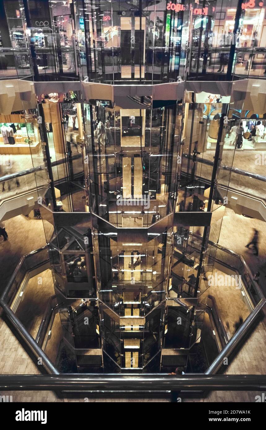 Three shiny glass-walled Otis elevators carry passengers to eight floors of Water Tower Place that features an unusual atrium-style shopping mall in downtown Chicago, Illinois, USA. Opened in 1976, it was one of the first vertical malls in the world and boasts over 100 shops. Water Tower Place is a popular destination for visitors to the Windy City and its famed Magnificent Mile, a 13-block stretch of North Michigan Avenue known for its upscale stores, restaurants and hotels. Stock Photo