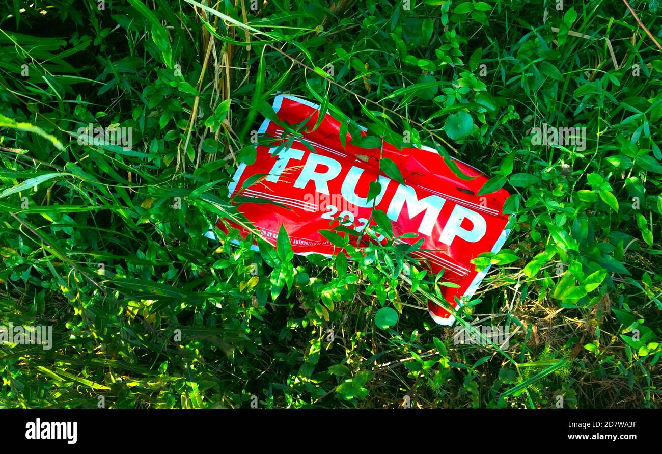 A political campaign sign for Donald J. Trump during the 2020 race for U.S. President has been discarded in the weeds on the west coast of Florida. That is one of the battleground states that determines who wins the four-year presidential office in a prolonged election season that pitted the Republican incumbent Trump against his Democratic party rival, Joseph R. Biden, Jr. Joe Biden was eventually the victor in the hard-fought contest. He previously served as the American vice president under Barack Obama for two terms from 2009 to 2017. Stock Photo