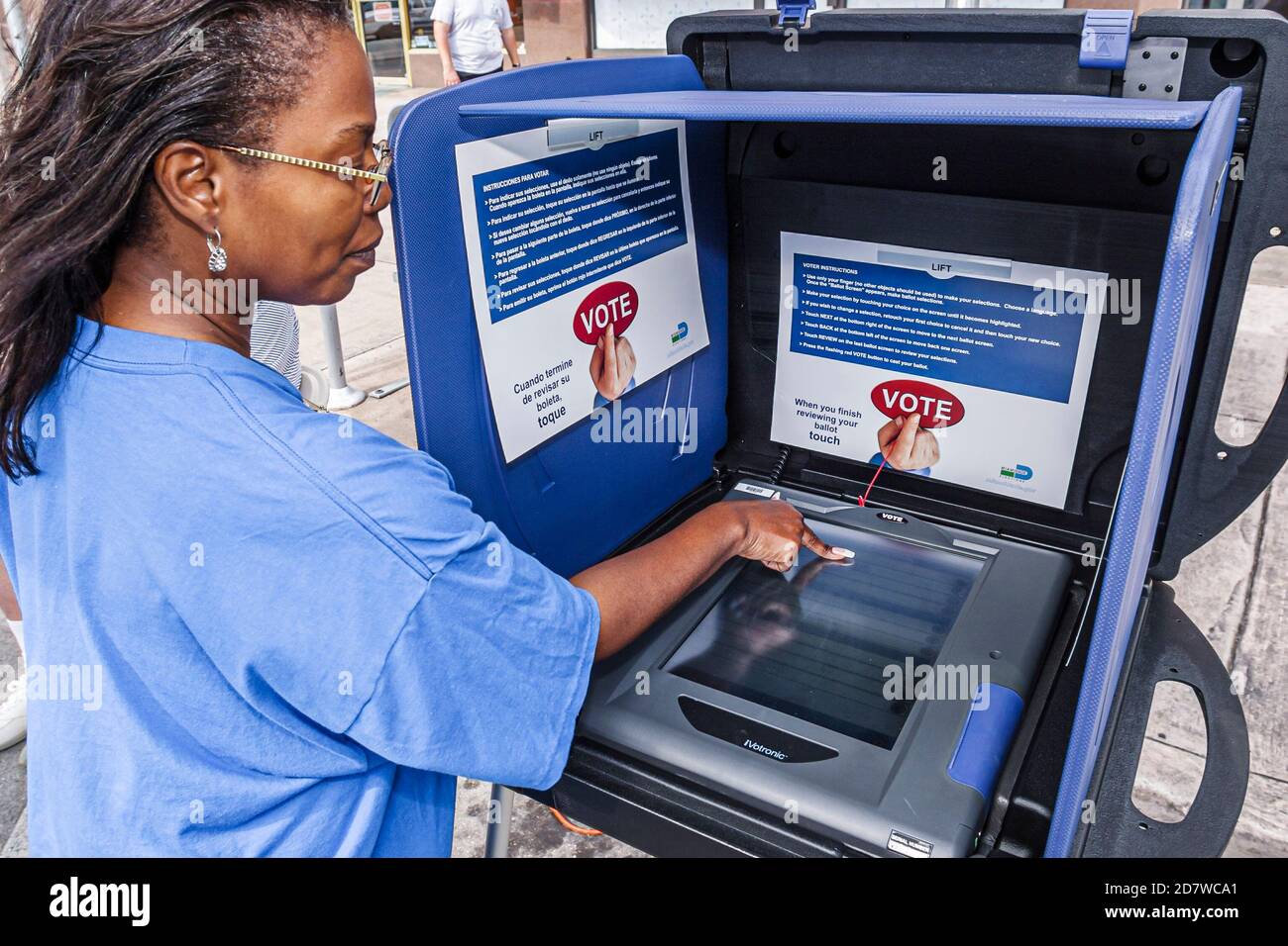 Miami Florida,Coral Gables demonstrating showing,voting booth how to vote use,touchscreen touch screen woman female Black city county employee worker Stock Photo