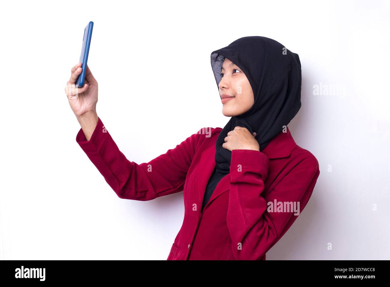 Happy Asian woman in hijab with mobile phone making selfie. Portrait of ...