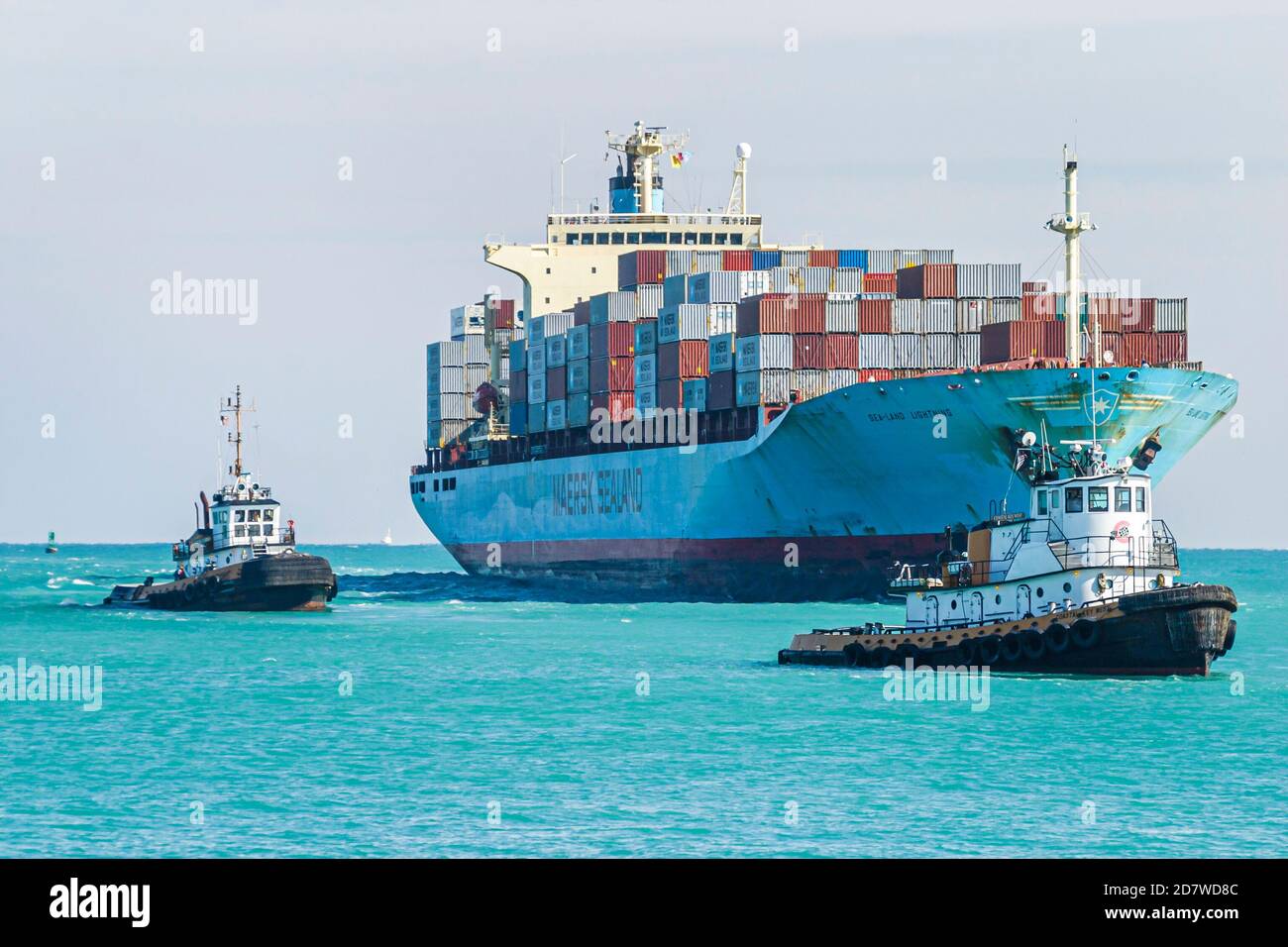 Miami Beach Florida,Atlantic Ocean cargo container ship loaded,approaches approaching arrives arriving Port of Miami tugboats, Stock Photo