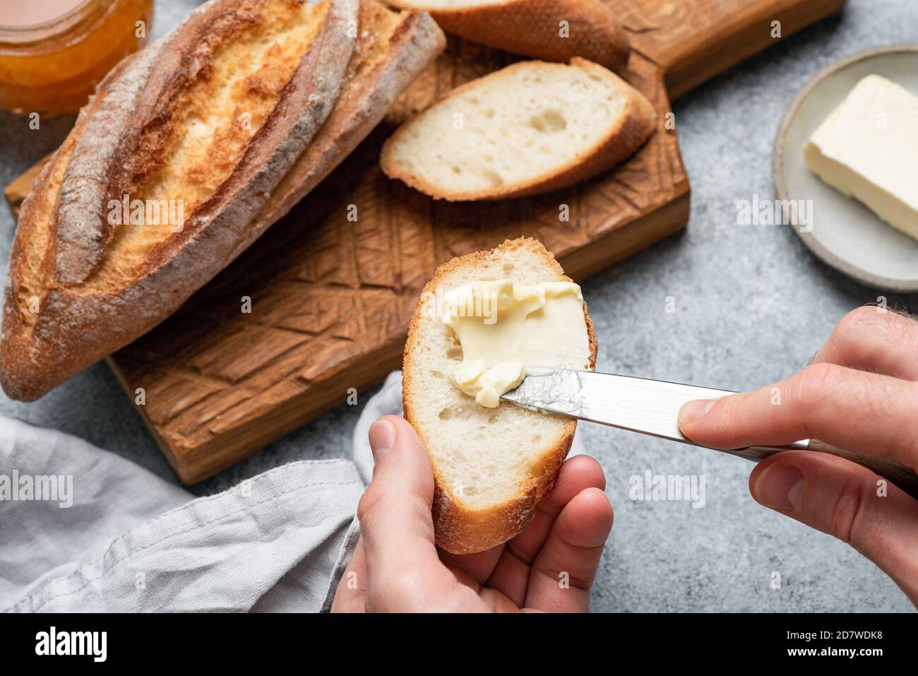 Smear butter on baguette bread. Making bread and butter sandwich Stock Photo Alamy