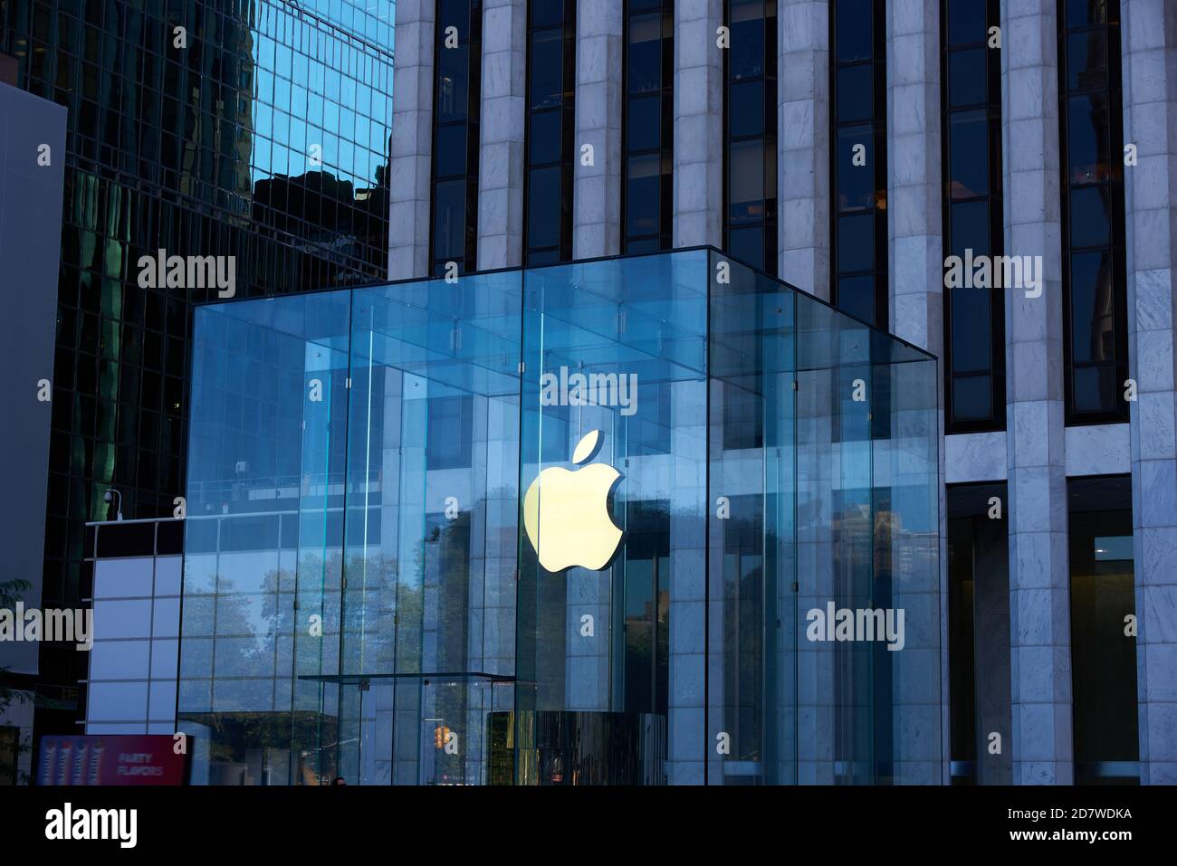 New York, NY - October 14, 2020: The Apple logo is illuminated with a warm light on a dark day at the Apple Store on 5th Avenue, Manhattan. The glass Stock Photo