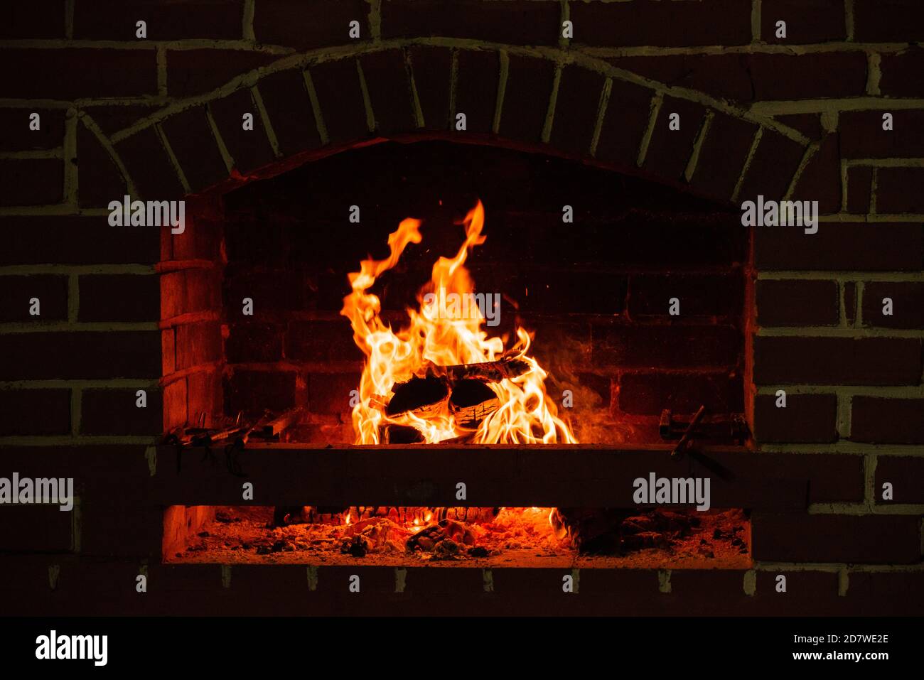 Fire in a fireplace. Wood burns in a cozy fireplace at home. Closeup of ...