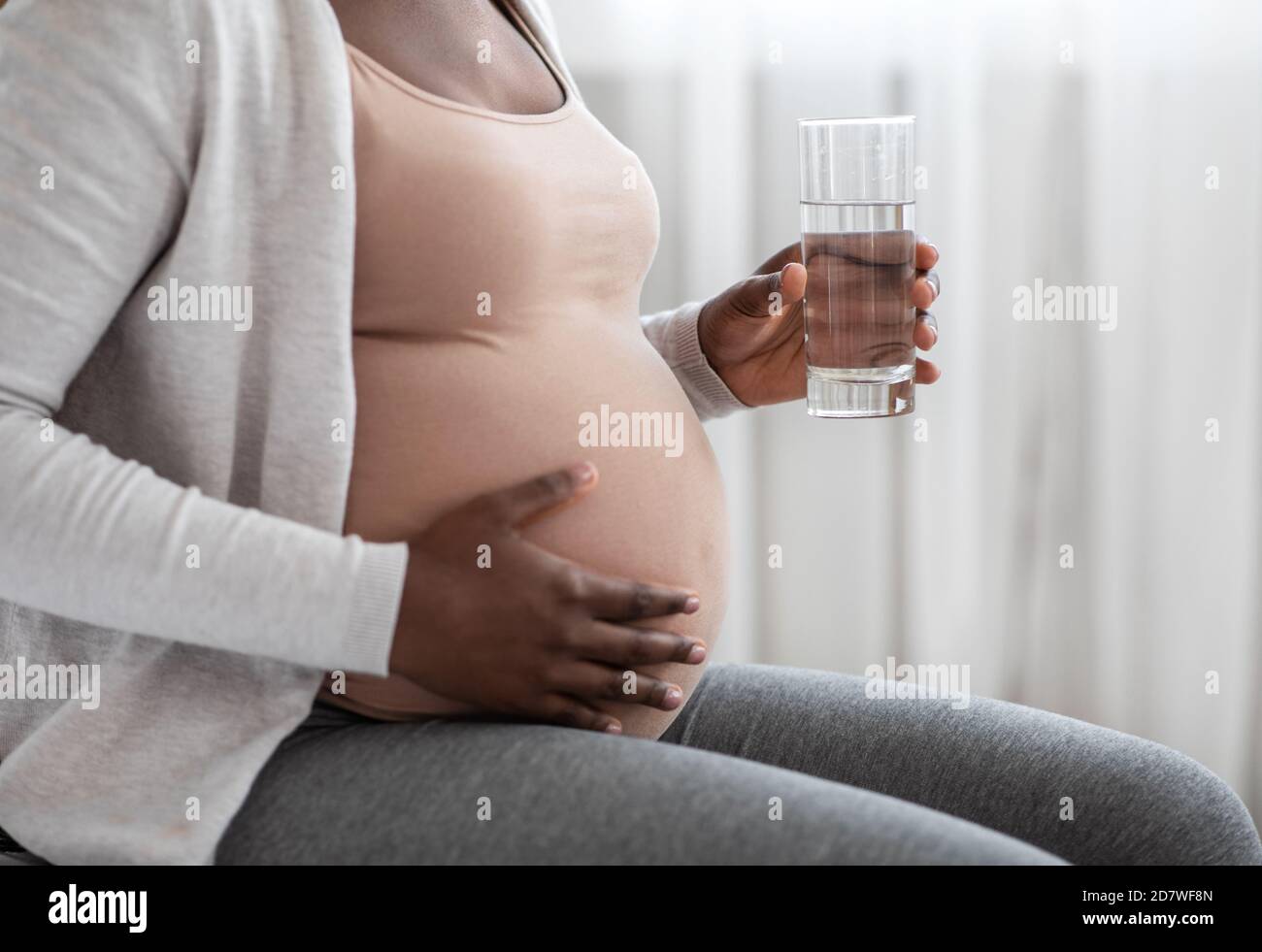 Pregnancy And Hydration. Black Pregnant Lady Drinking Mineral Water And