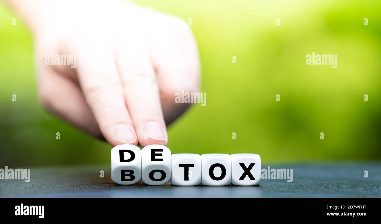 Detox instead of Botox. Hand turns a dice and changes the expression 'Botox' to 'Detox'. Stock Photo