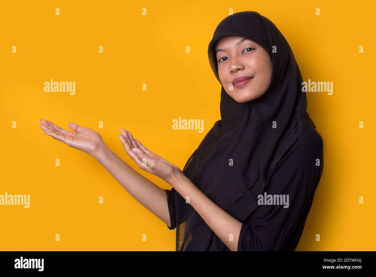 Young asian beautiful woman wearing hijab on yellow background smiling ...