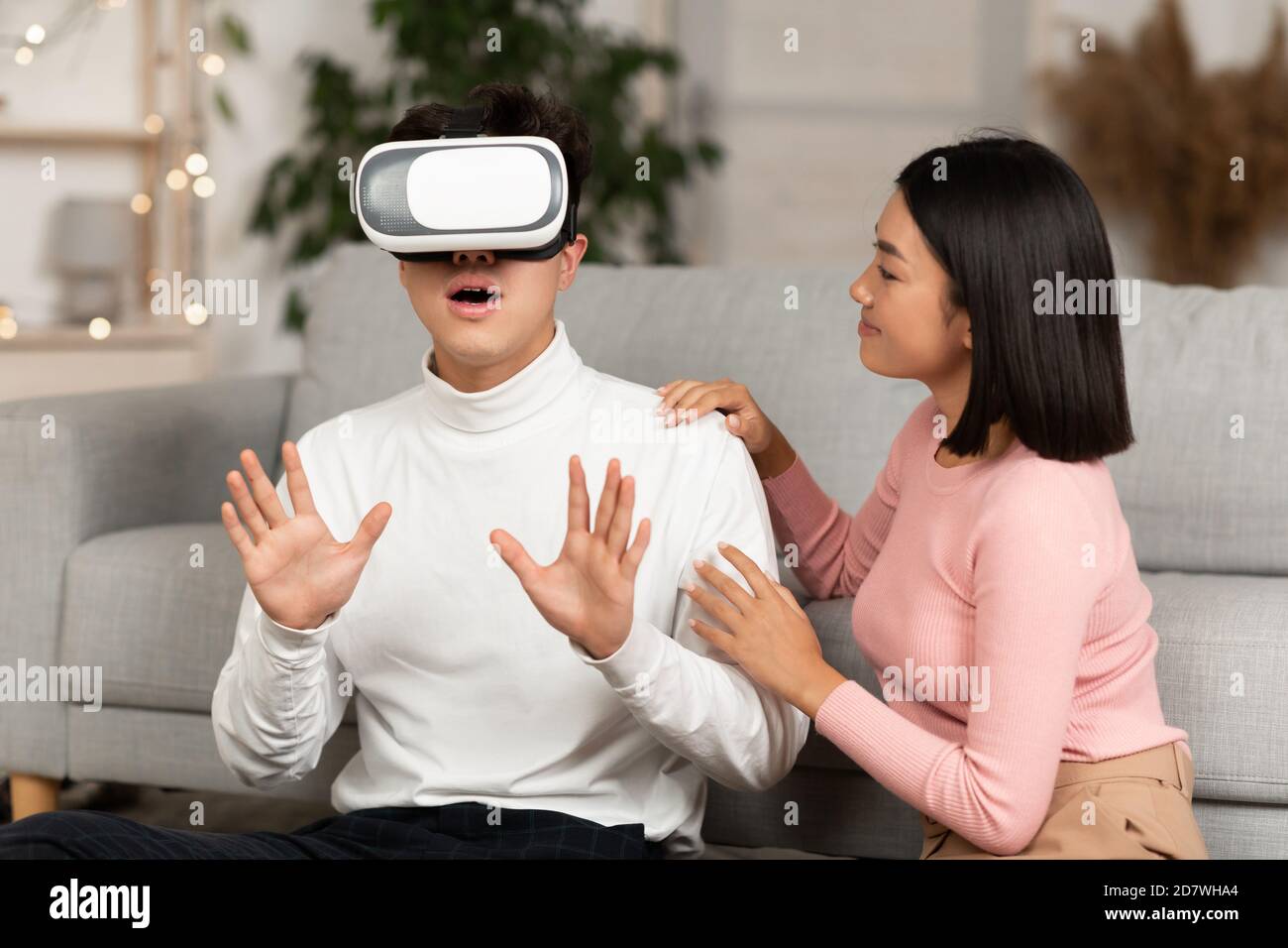 Millennial Couple Using Virtual Reality Glasses Playing Game At Home Stock Photo