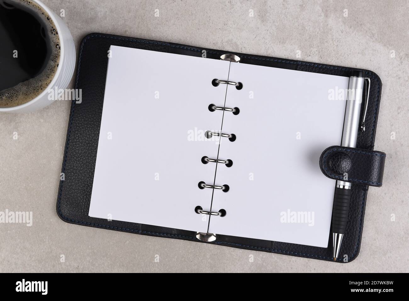 Flat Lay still life of a business desk with Coffee Cup, and small ring binder open to blank pages Stock Photo